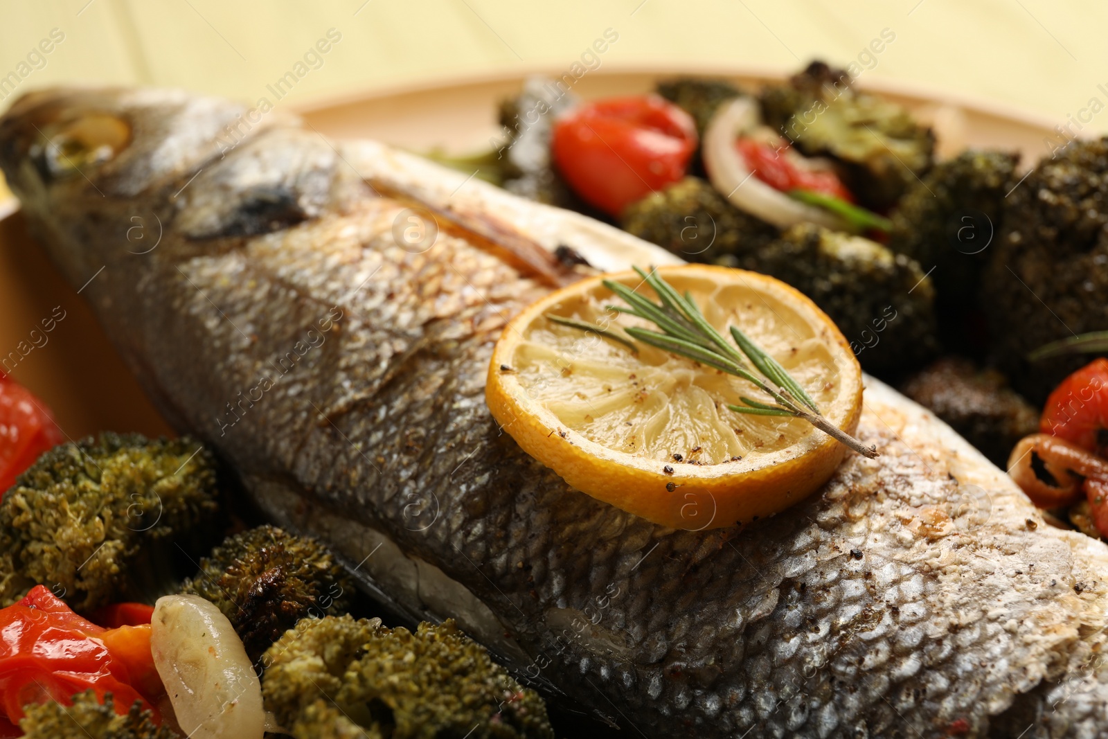 Photo of Delicious baked fish and vegetables on plate, closeup