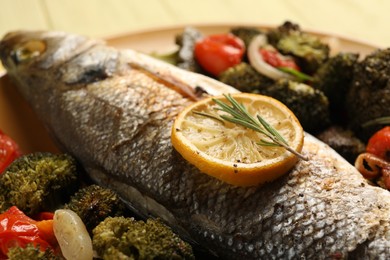 Photo of Delicious baked fish and vegetables on plate, closeup