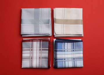 Stylish handkerchiefs on red background, flat lay