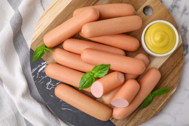 Photo of Delicious boiled sausages, sauce and basil on table, top view