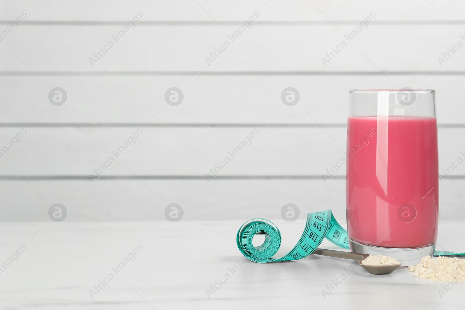 Photo of Tasty shake, measuring tape and powder on white marble table, space for text. Weight loss