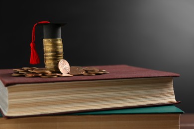 Scholarship concept. Graduation cap and coins on books, closeup with space for text