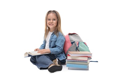 Photo of Cute little girl with books and backpack on white background