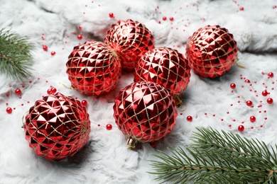 Beautiful Christmas baubles and fir tree branches on white fur