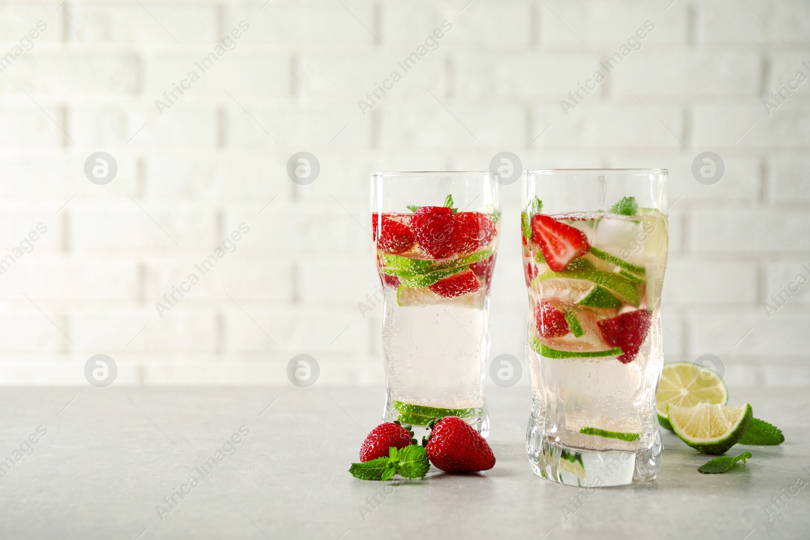 Photo of Tasty refreshing drink on light grey table. Space for text