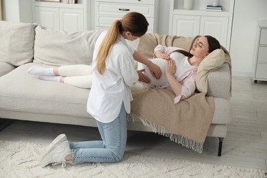 Doula taking care of pregnant woman at home. Preparation for child birth