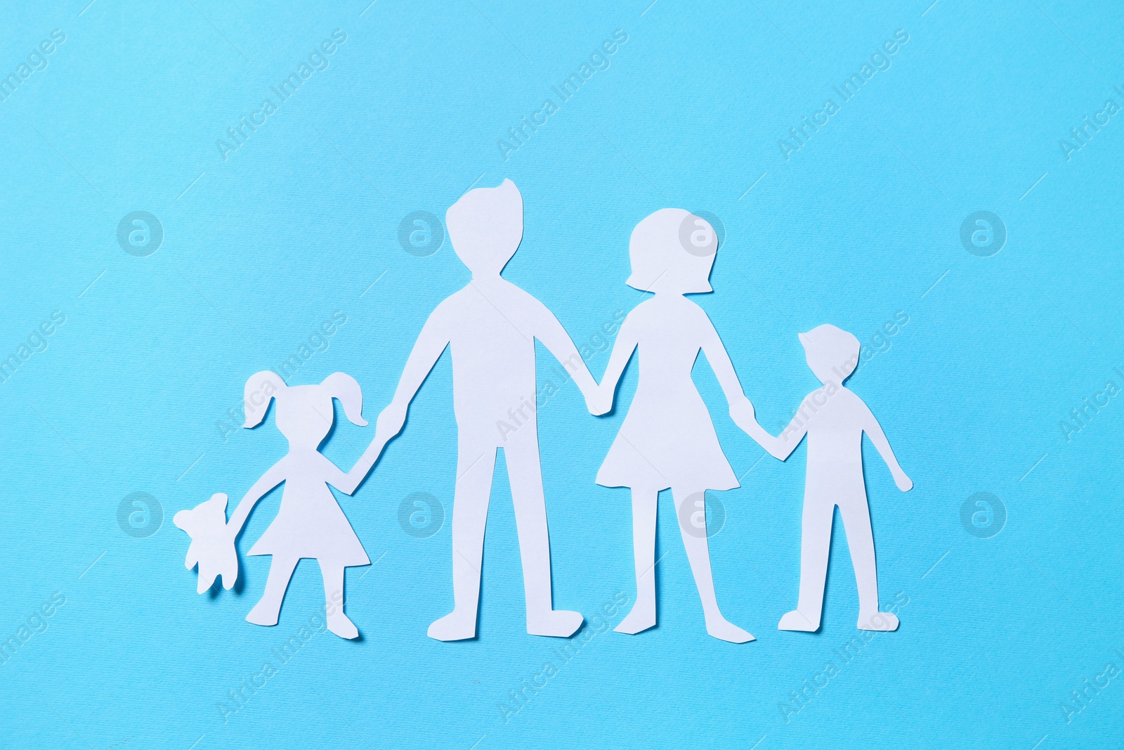 Photo of Paper family figures on light blue background, top view