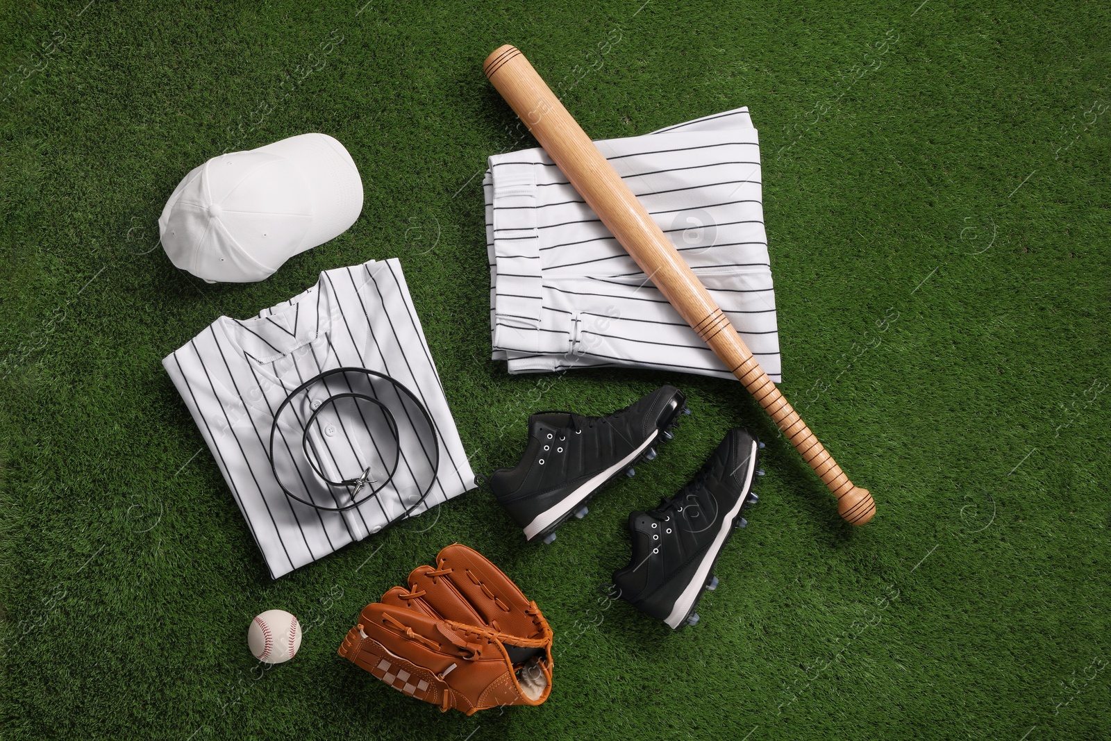 Photo of Flat lay composition with baseball equipment on artificial grass