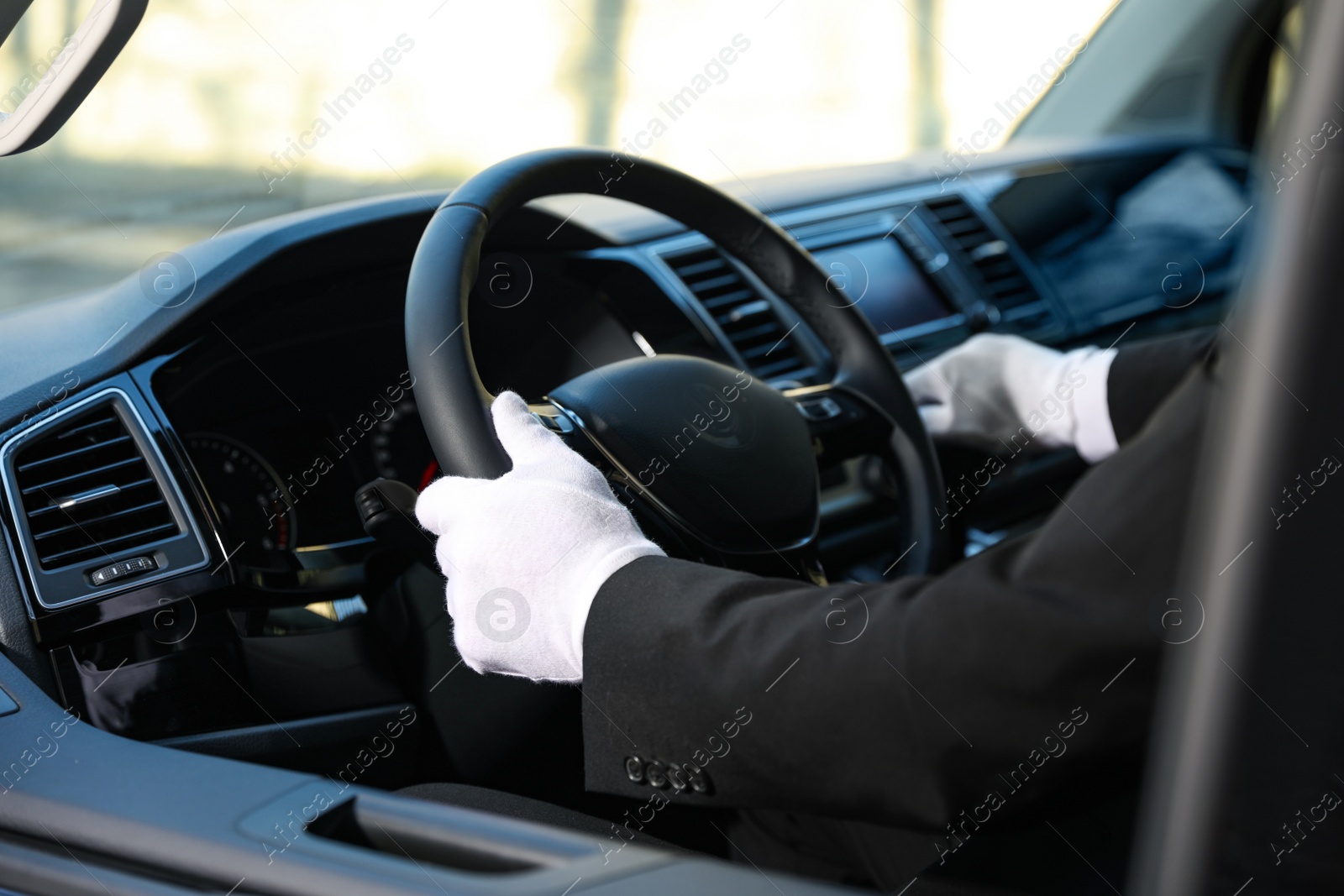 Photo of Professional driver in luxury car, closeup. Chauffeur service