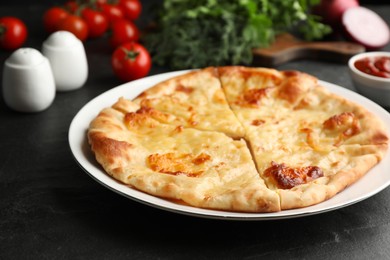 Photo of Delicious khachapuri with cheese on black table, closeup