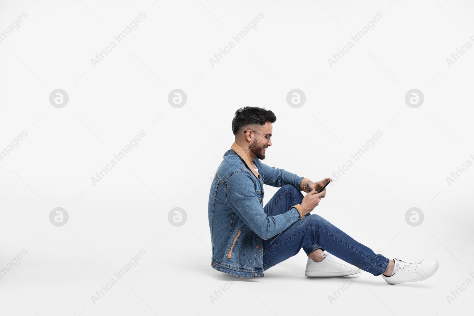 Photo of Handsome man using smartphone on white background, space for text