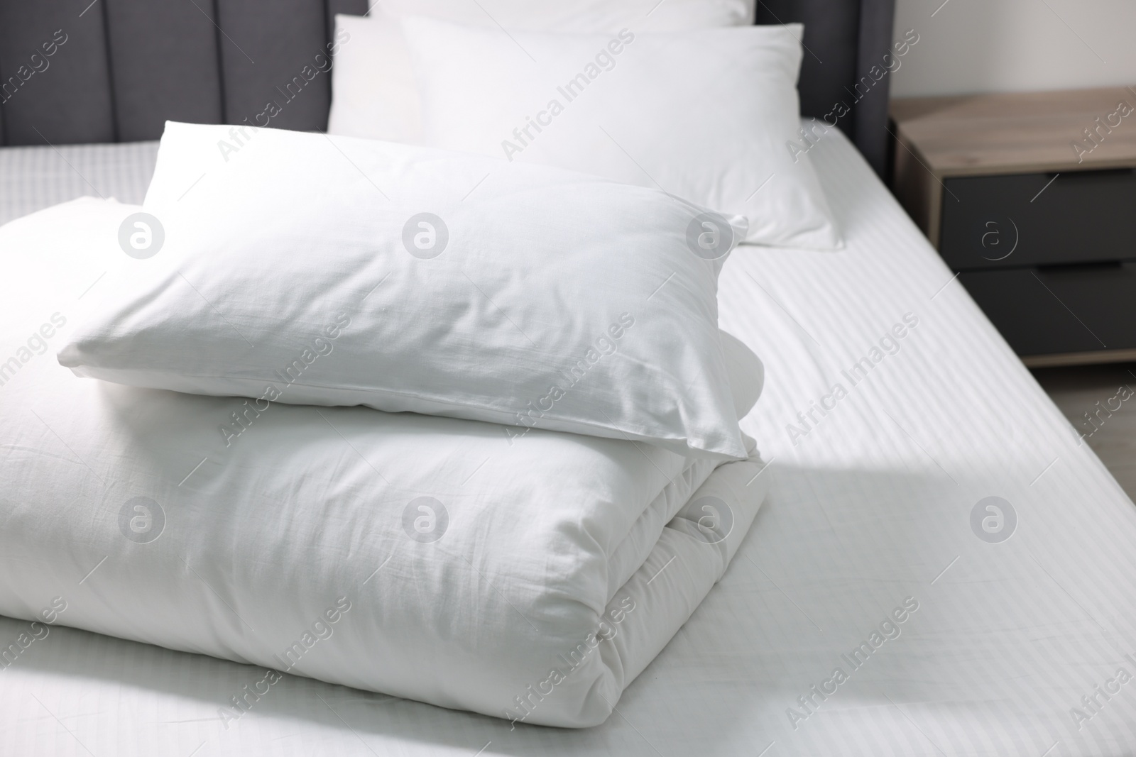 Photo of Soft white pillows and duvet on bed at home. Space for text