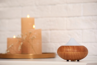 Photo of Modern essential oil diffuser on table indoors