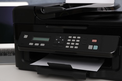 Closeup view of new modern printer with control panel on white table