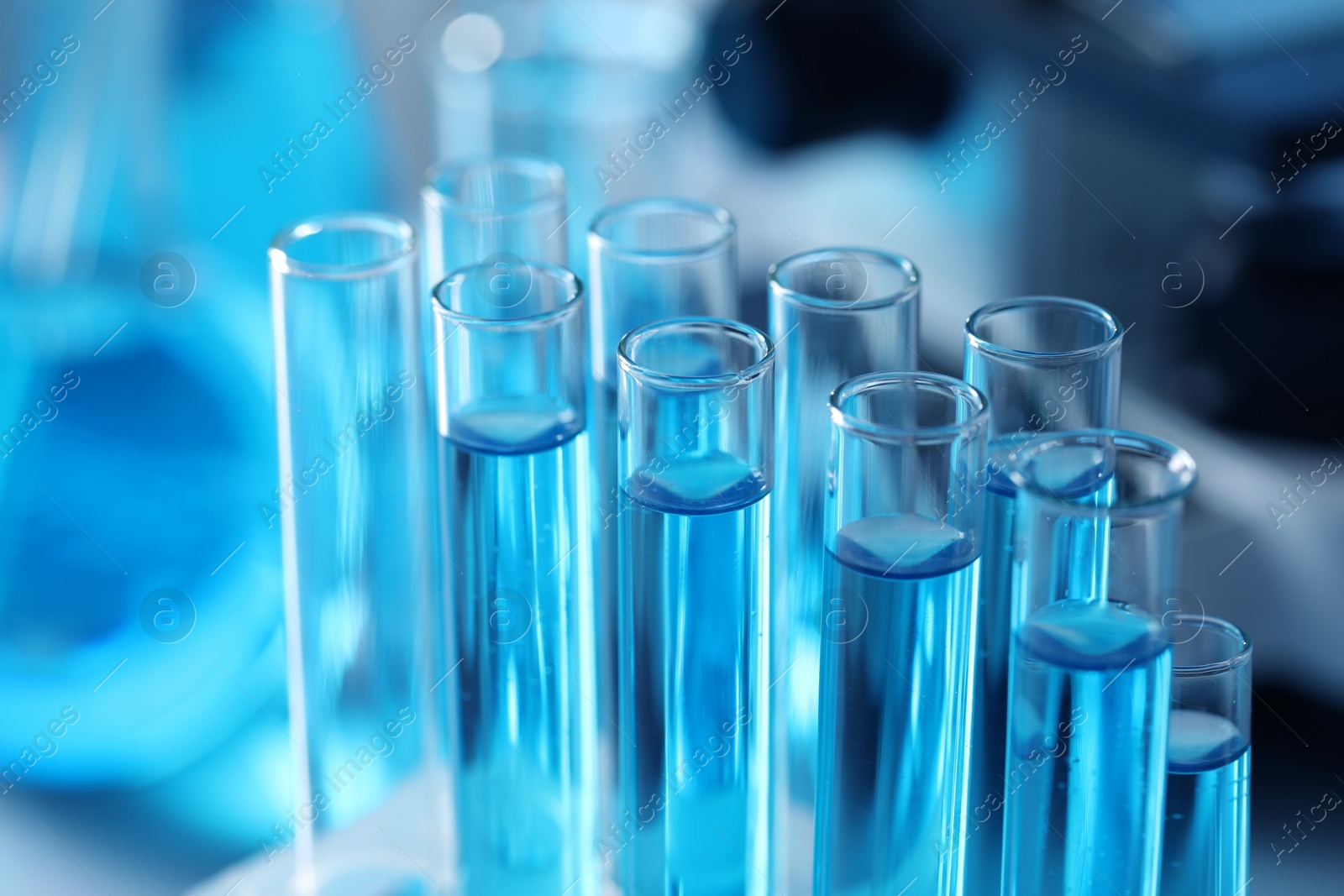 Photo of Test tubes with light blue liquid in laboratory, closeup