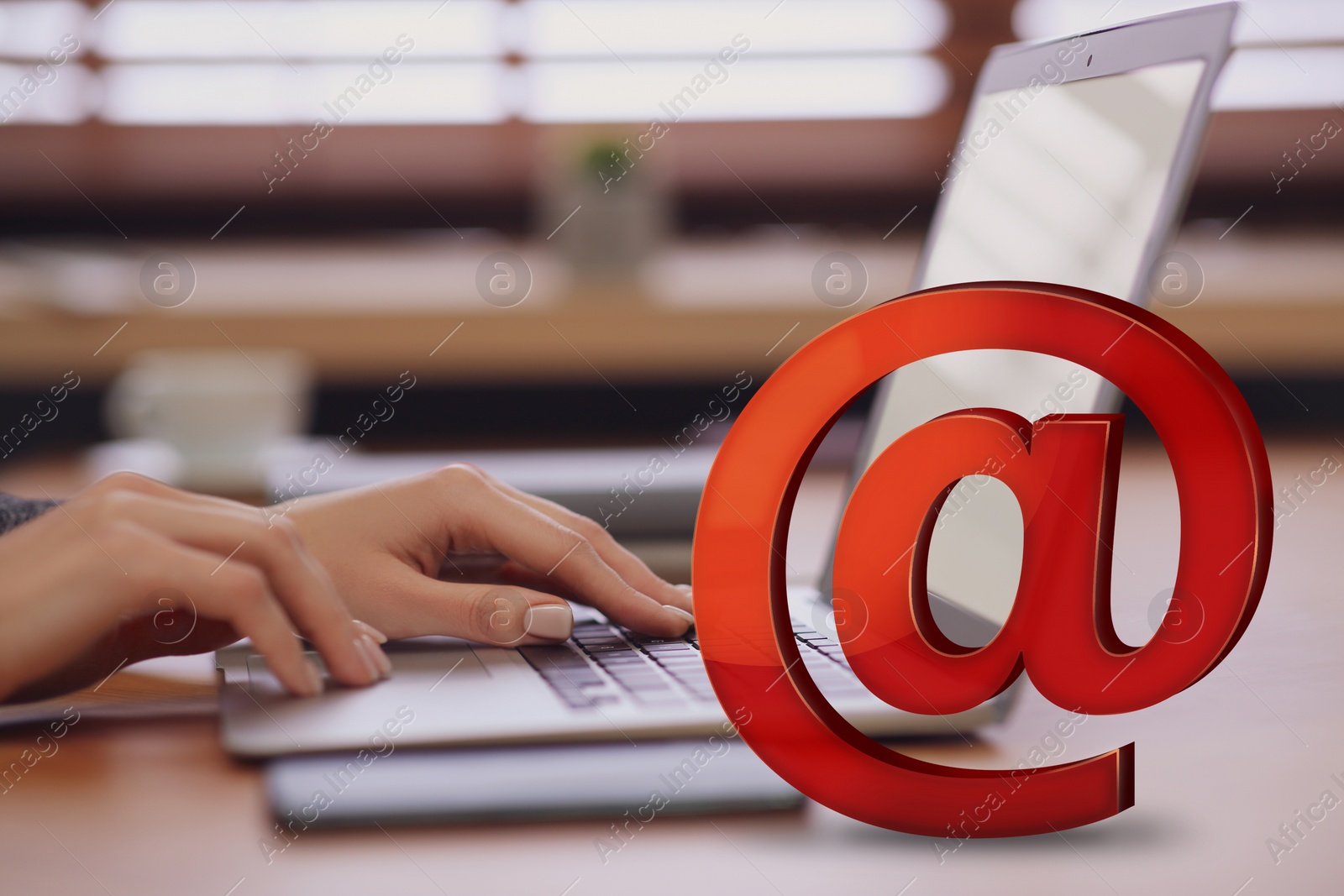 Image of At sign illustration and woman sending email via laptop at table, closeup