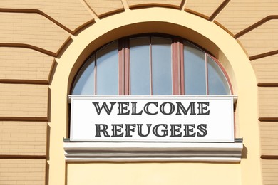 Banner with phrase WELCOME REFUGEES on building