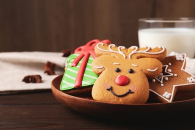 Plate with tasty Christmas cookies on wooden table, closeup