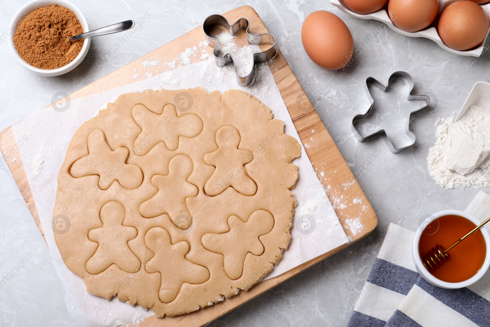 Photo of Making homemade Christmas cookies on light grey marble table, above view. Ingredients for gingerbread men