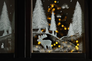 Beautiful drawing made with artificial snow on window. Christmas decor