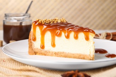 Photo of Tasty cheesecake with caramel and nuts served on table, closeup