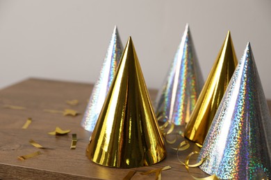 Birthday party hats, serpentine streamers and confetti on wooden table