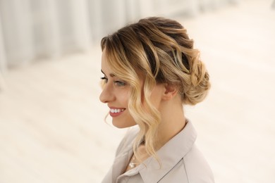 Smiling woman with beautiful hair style indoors