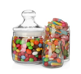 Glass jars with different candies on white background