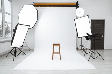 Photo of Interiormodern photo studio with bar stool and professional lighting equipment