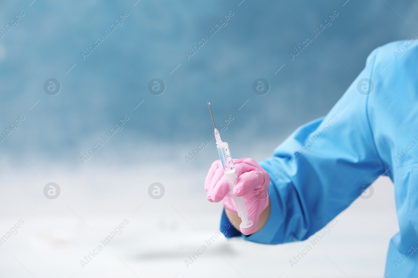 Photo of Doctor in medical glove with syringe on color background. Space for text