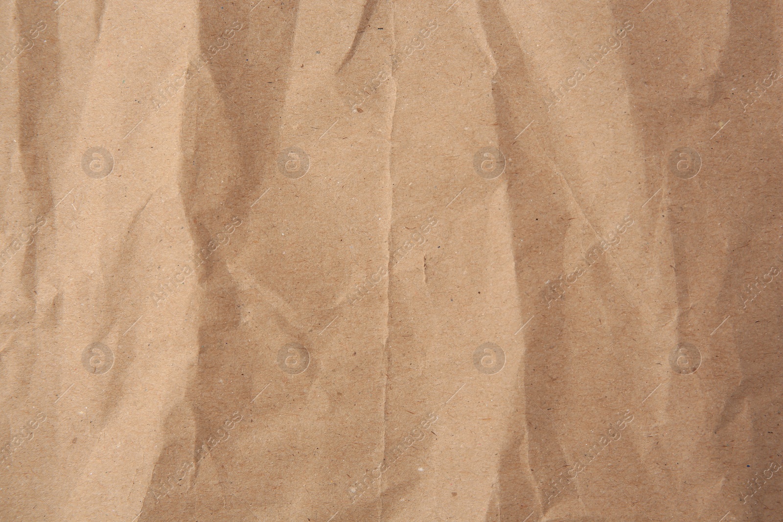 Photo of Sheet of crumpled kraft paper as background, top view