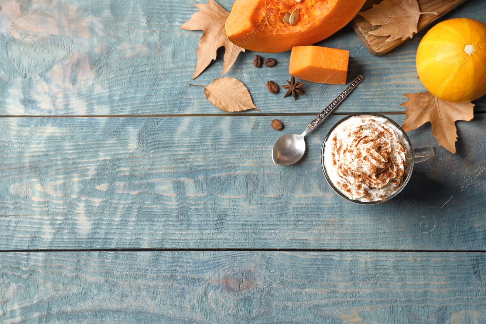 Photo of Flat lay composition with glass cup of tasty pumpkin spice latte and space for text on wooden background