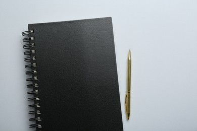 Photo of One notebook and pen on light grey background, top view