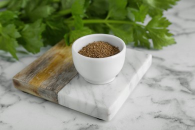 Photo of Bowl of celery seeds on white marble table