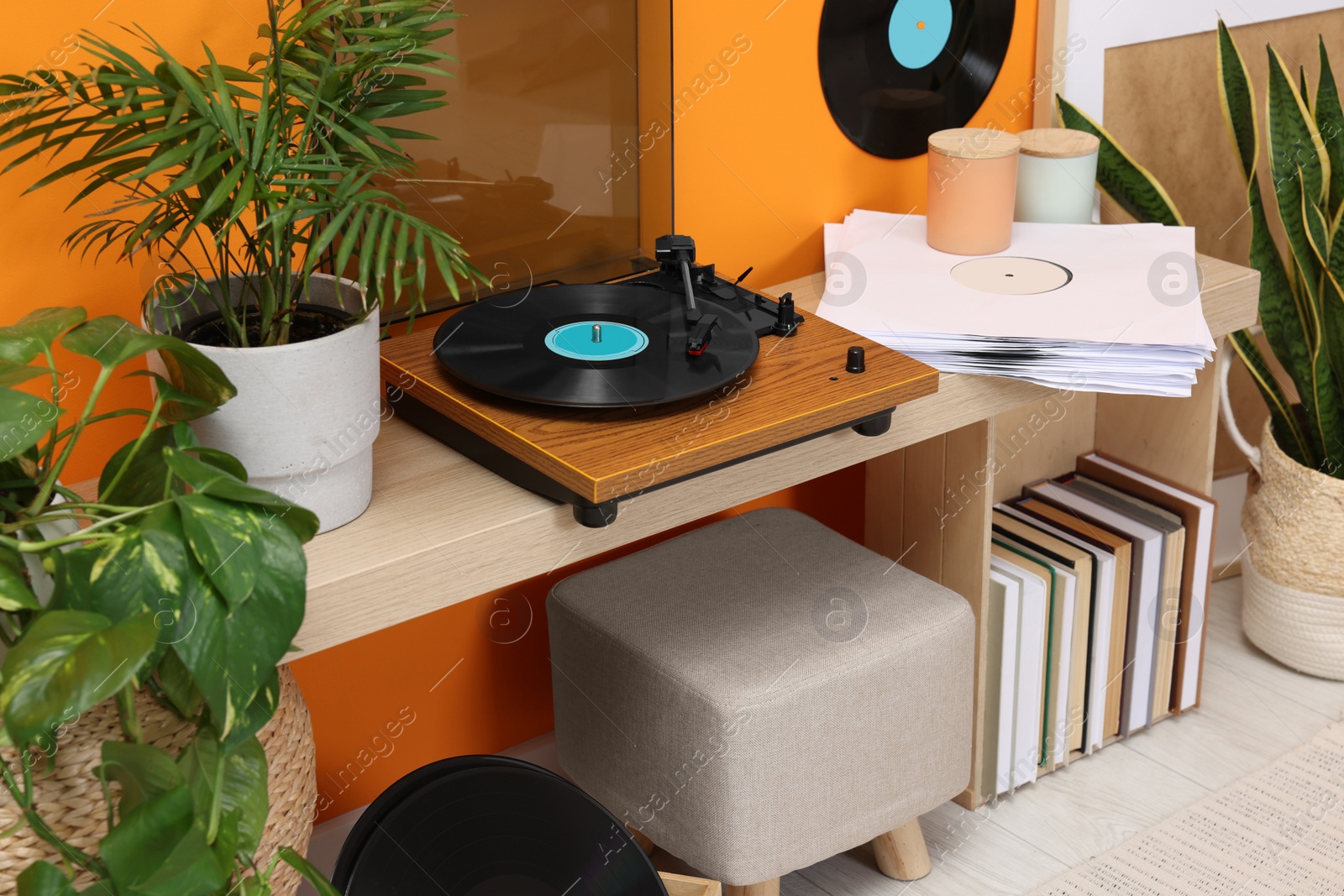 Photo of Stylish turntable with vinyl record on console table in cozy room