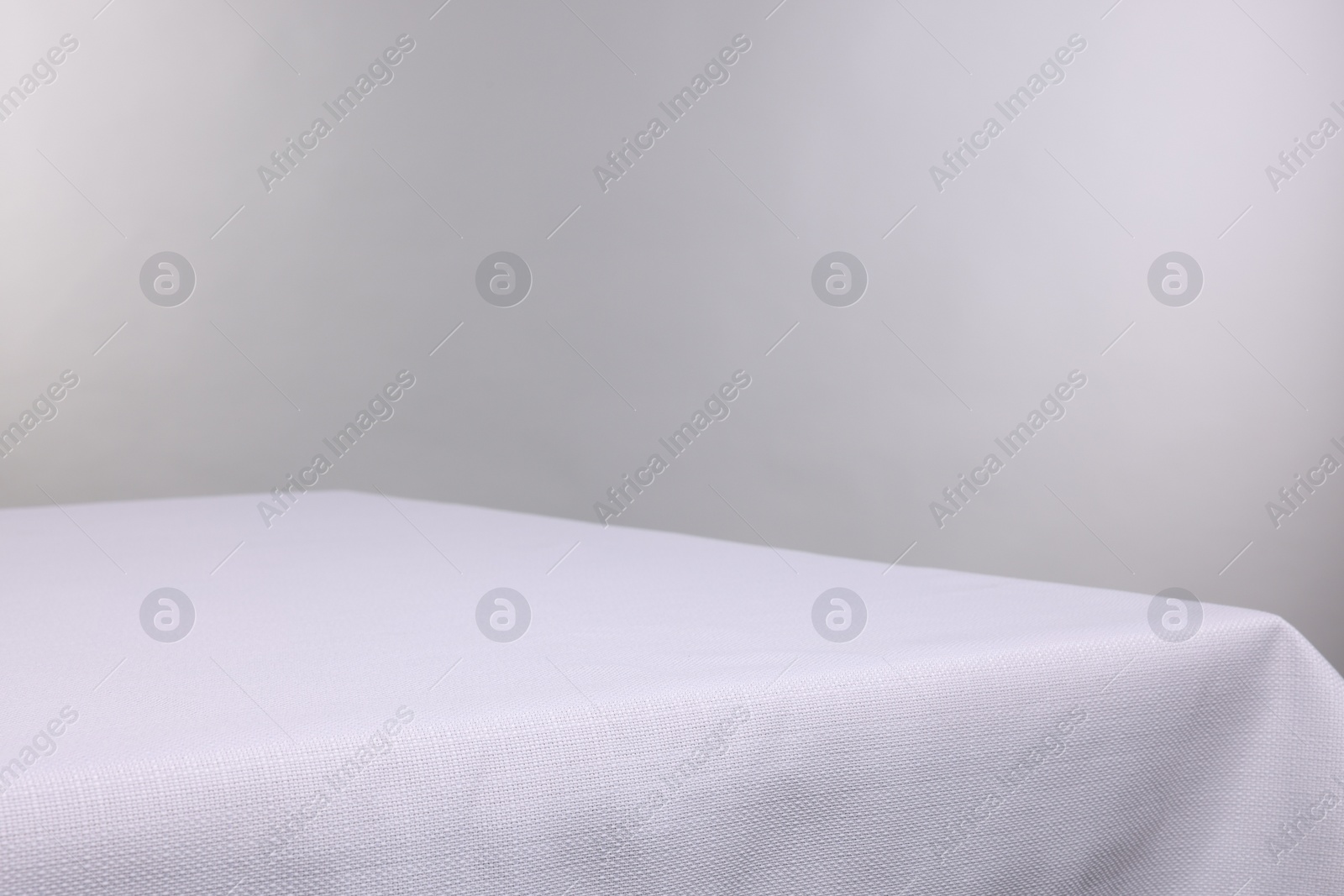 Photo of Empty table with tablecloth isolated on white