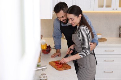 Happy lovely couple cooking together in kitchen