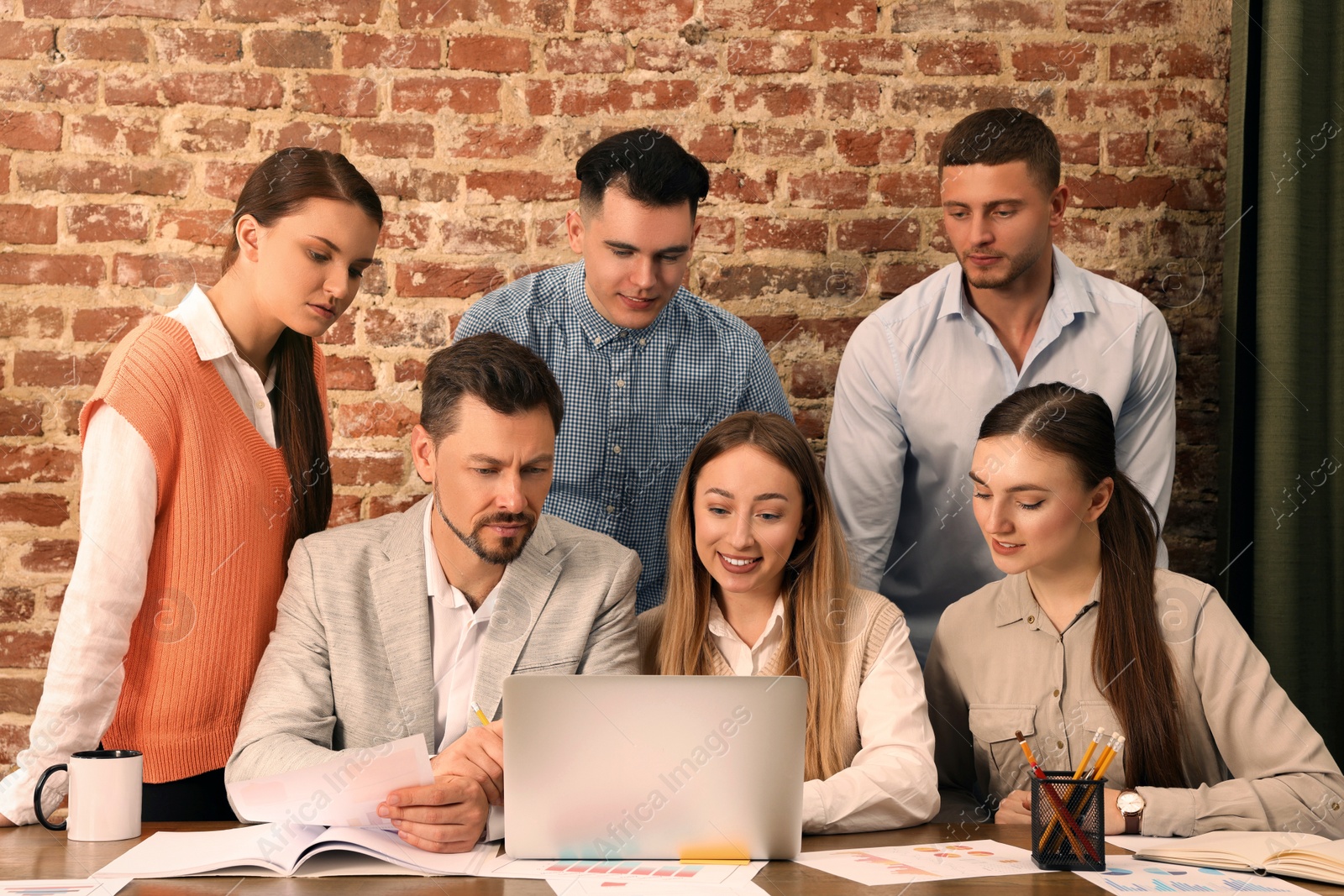 Photo of Team of employees working together in office