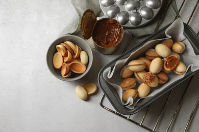 Photo of Delicious walnut shaped cookies with condensed milk on grey table, flat lay. Space for text