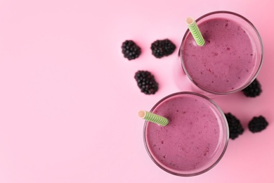 Delicious blackberry smoothie on pink background, flat lay. Space for text