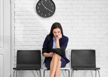 Photo of Young woman waiting for job interview, indoors