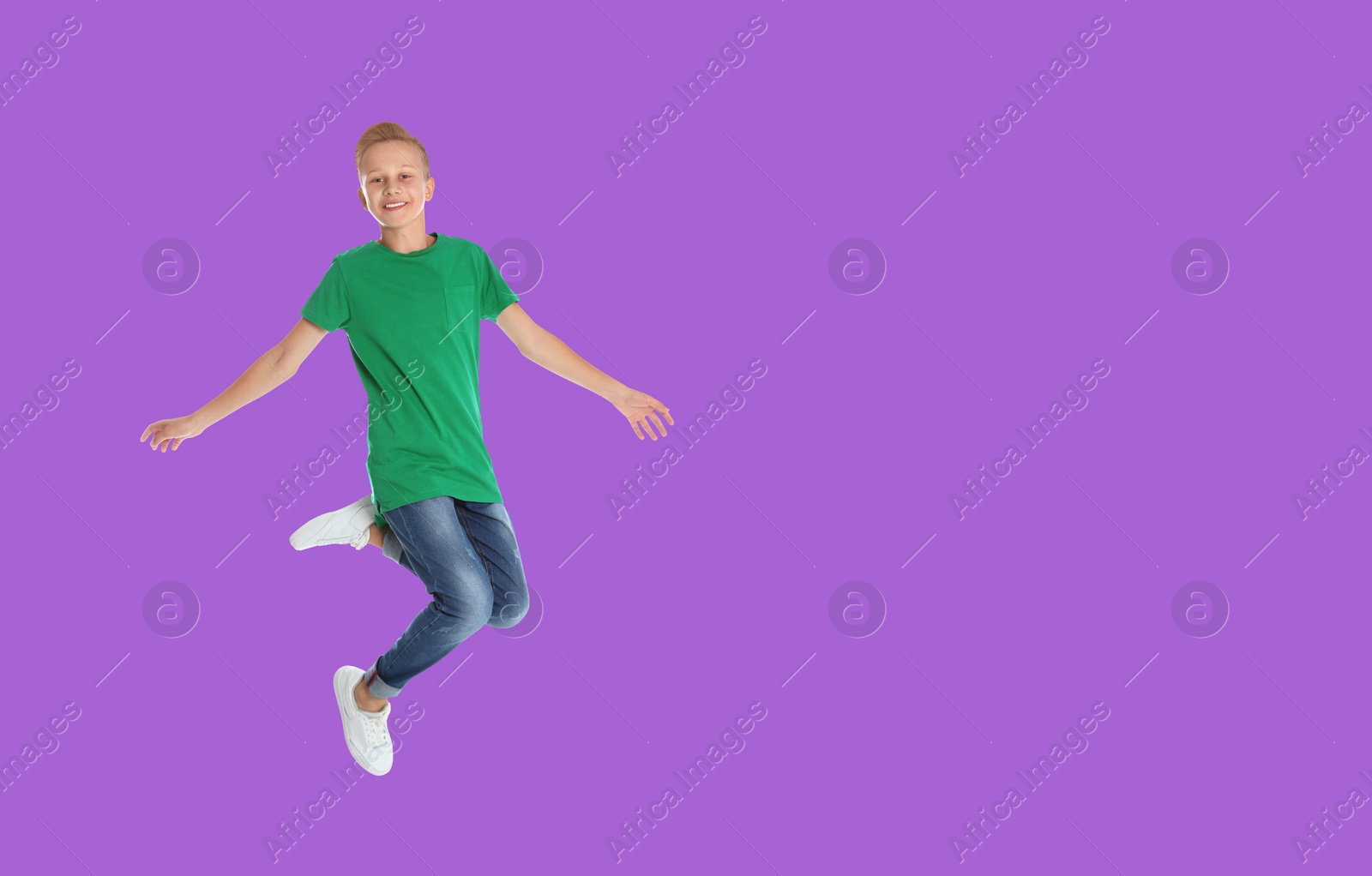 Image of Happy boy jumping on violet background, space for text