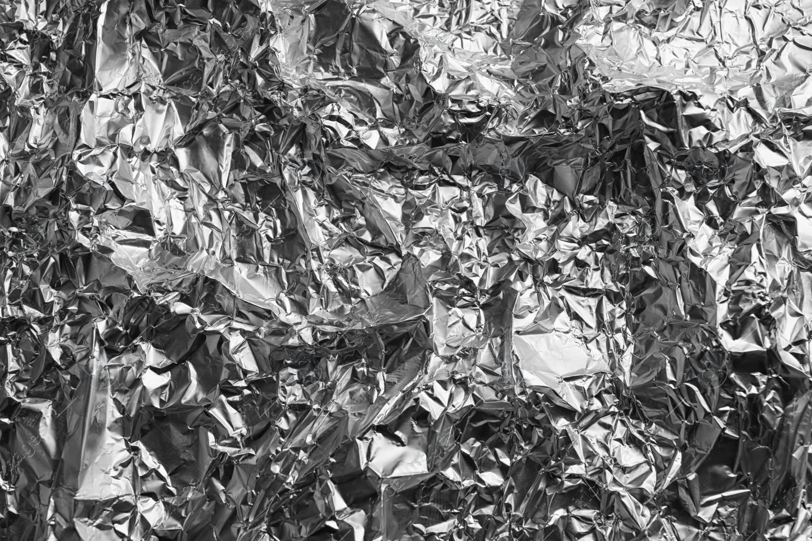 Photo of Crumpled silver foil as background, closeup view