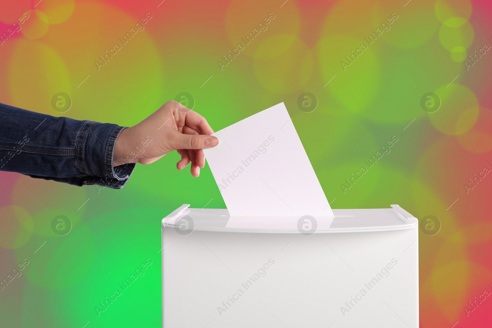 Image of Woman putting her vote into ballot box on color background, closeup