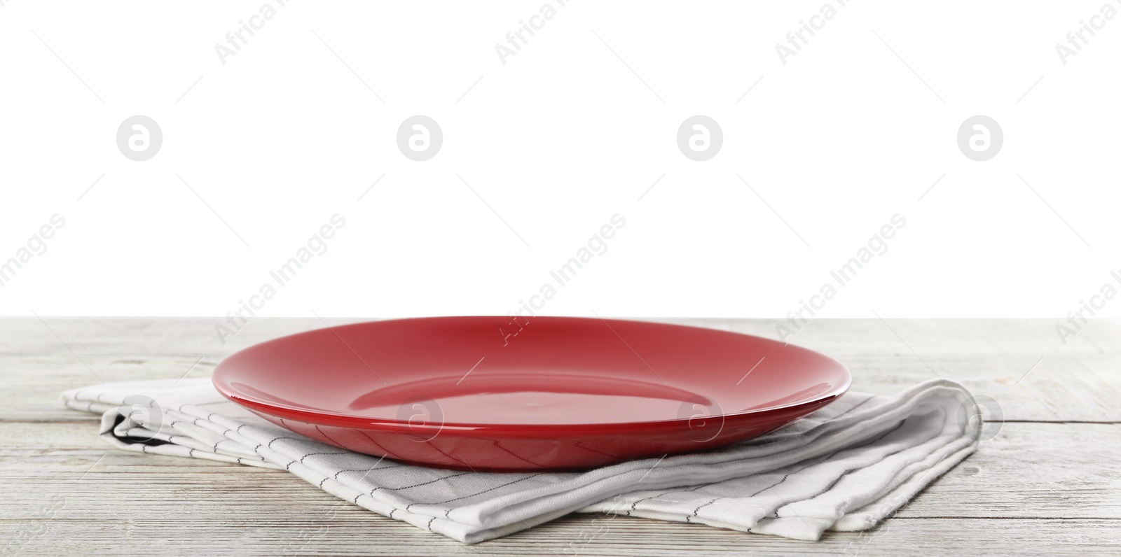 Photo of Empty red plate and napkin on wooden table against white background