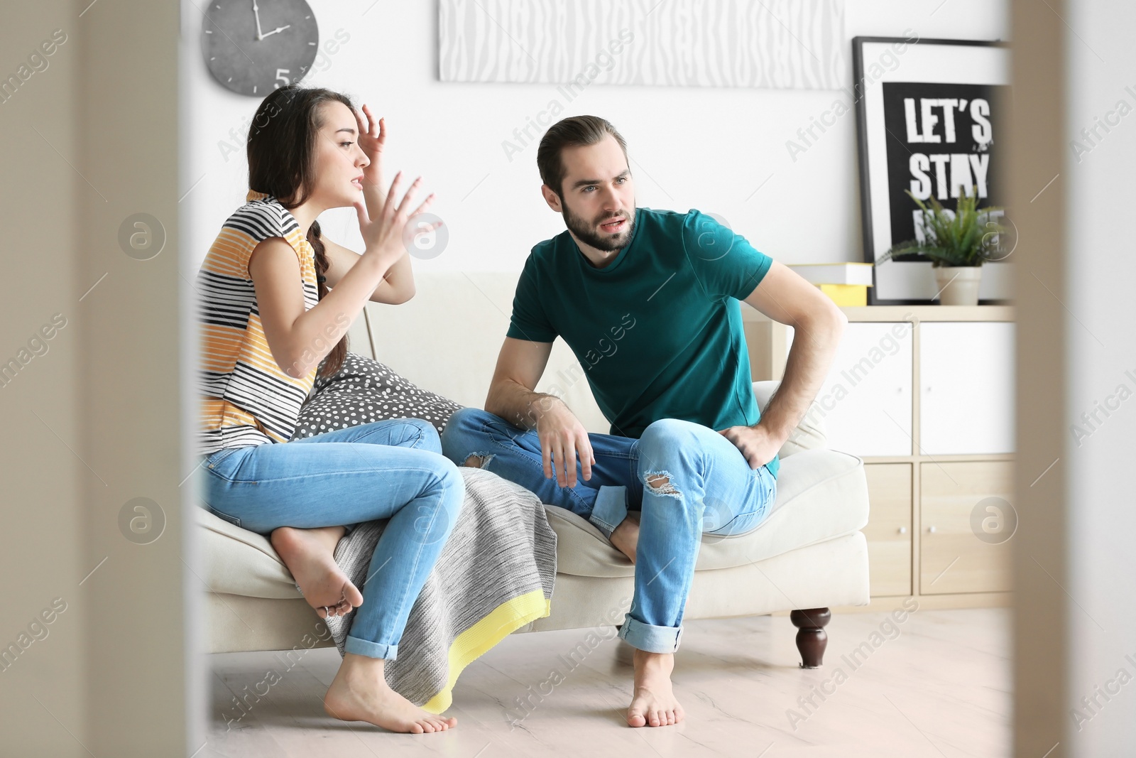 Photo of Young couple having argument in living room