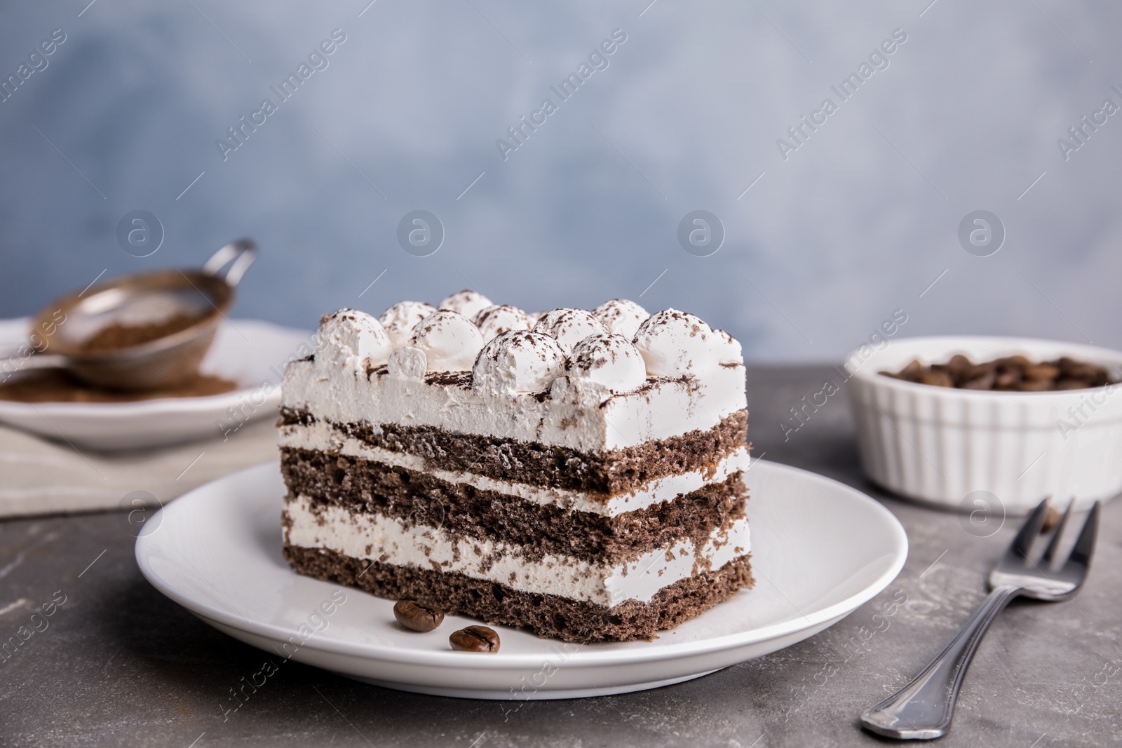 Photo of Plate of delicious tiramisu cake on grey table