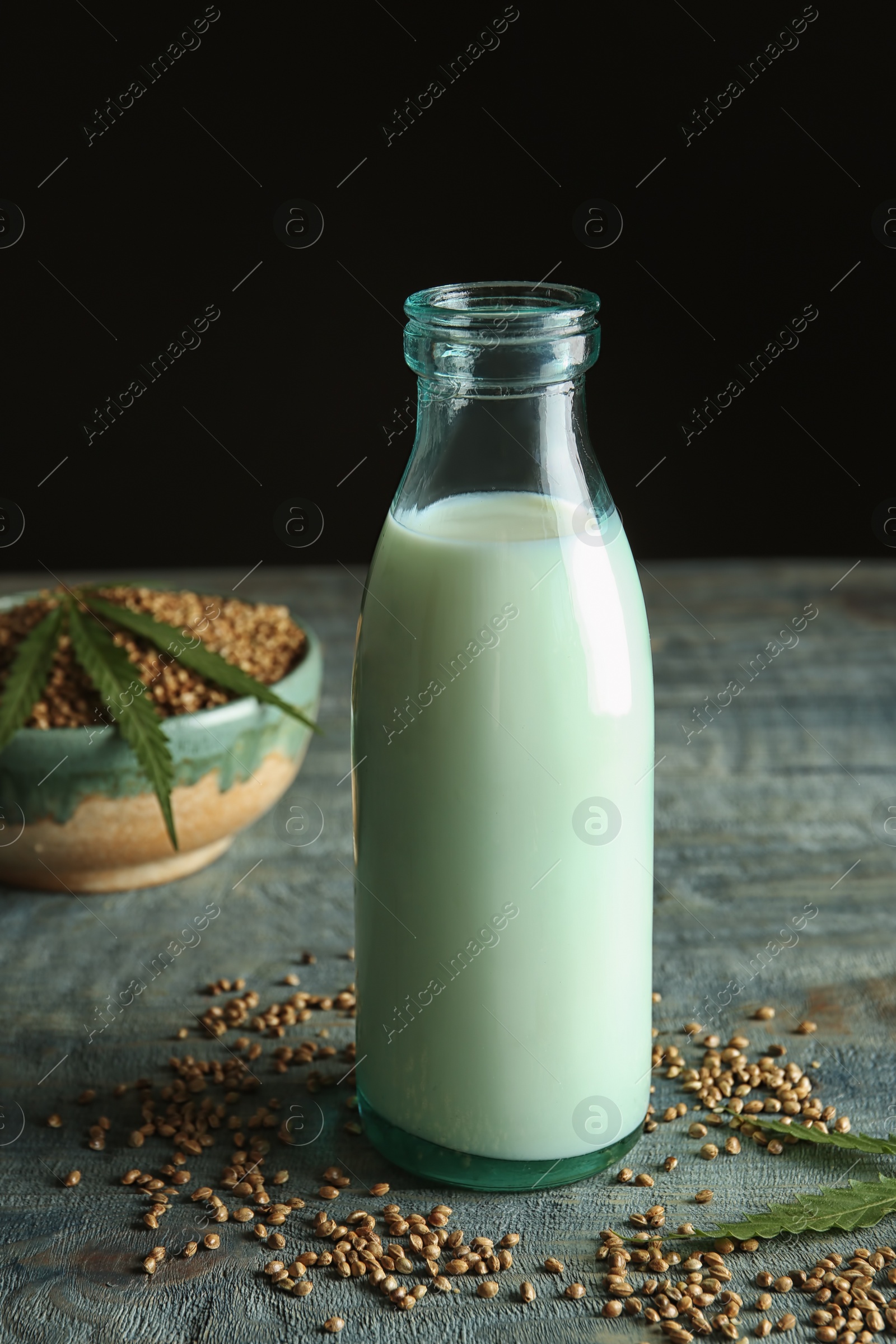 Photo of Bottle of hemp milk on wooden table