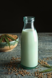 Photo of Bottle of hemp milk on wooden table