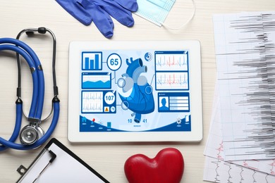Photo of Flat lay composition with tablet and red heart on white wooden table. Cardiology concept